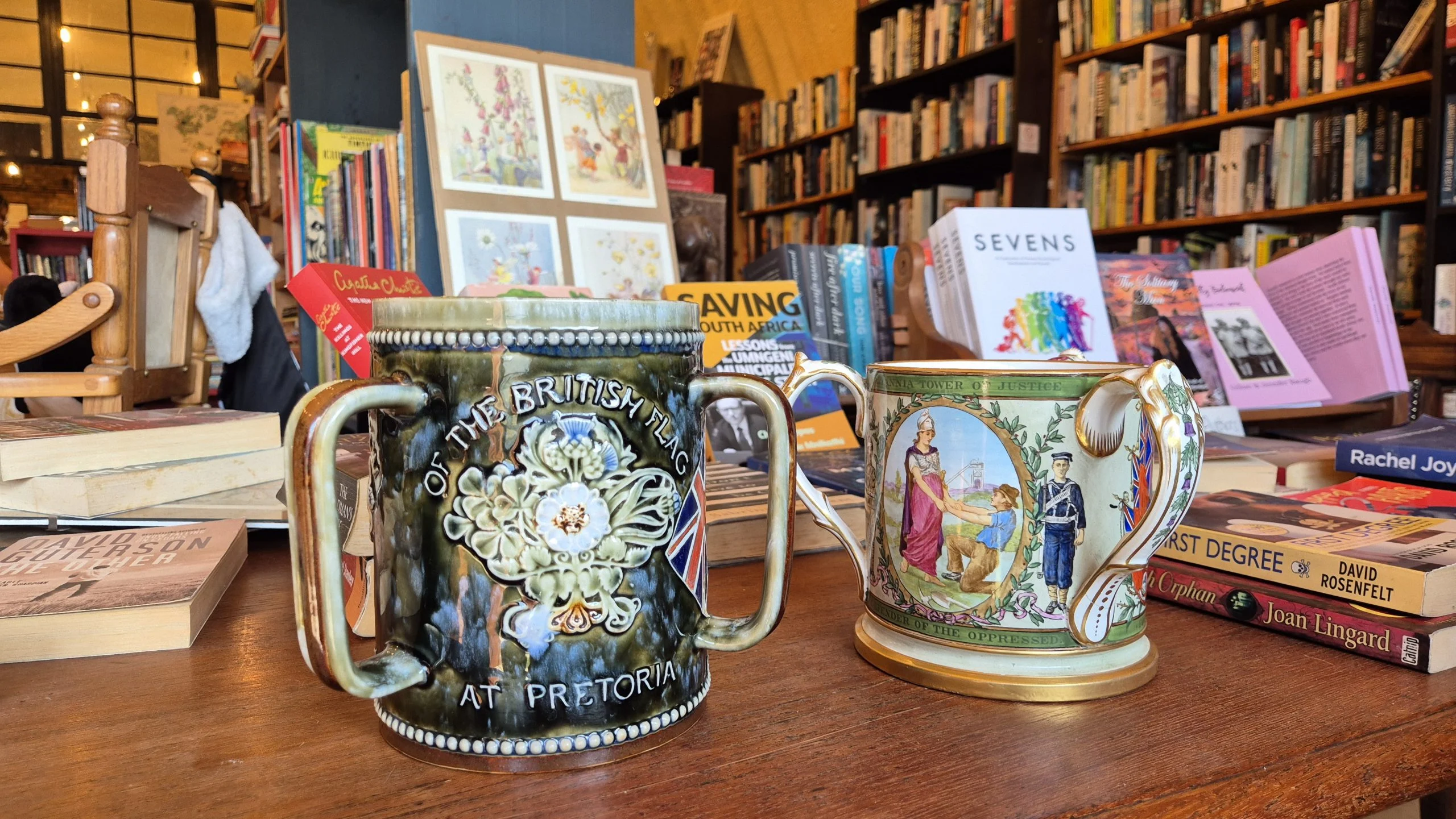 Three-handled Anglo-Boer War mugs (tygs) at Midlands Books, commemorating the Boer War with an embossed Queen Victoria and Union Jack.