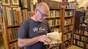 Should you wear gloves to handle old books? Rob at Midlands Books handling a rare old book with clean bare hands.