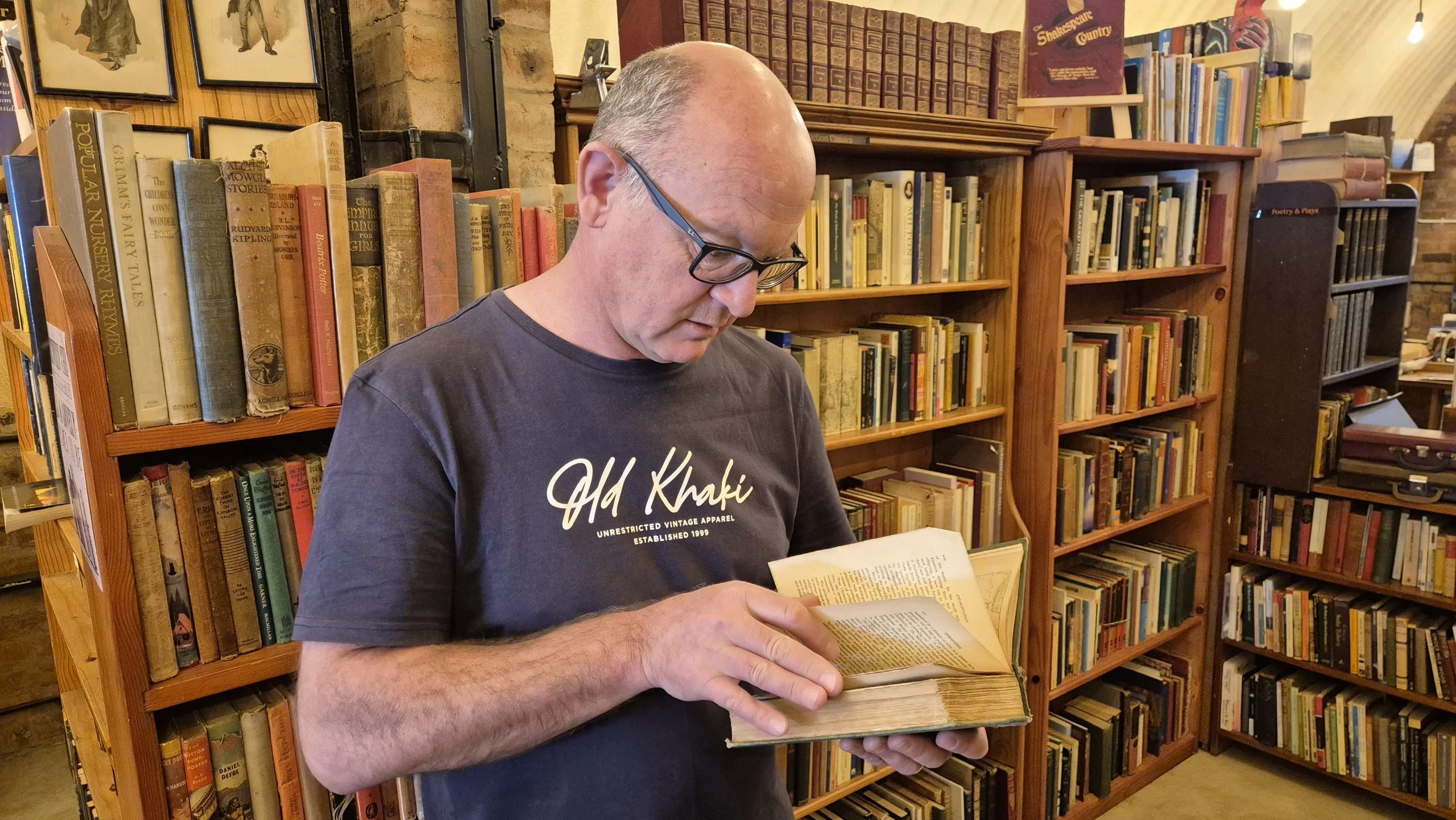 Should you wear gloves to handle old books? Rob at Midlands Books handling a rare old book with clean bare hands.